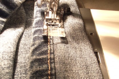 Turn the jeans in the right way, adjust the pins so the side seams line up and stitch very close to the turn line